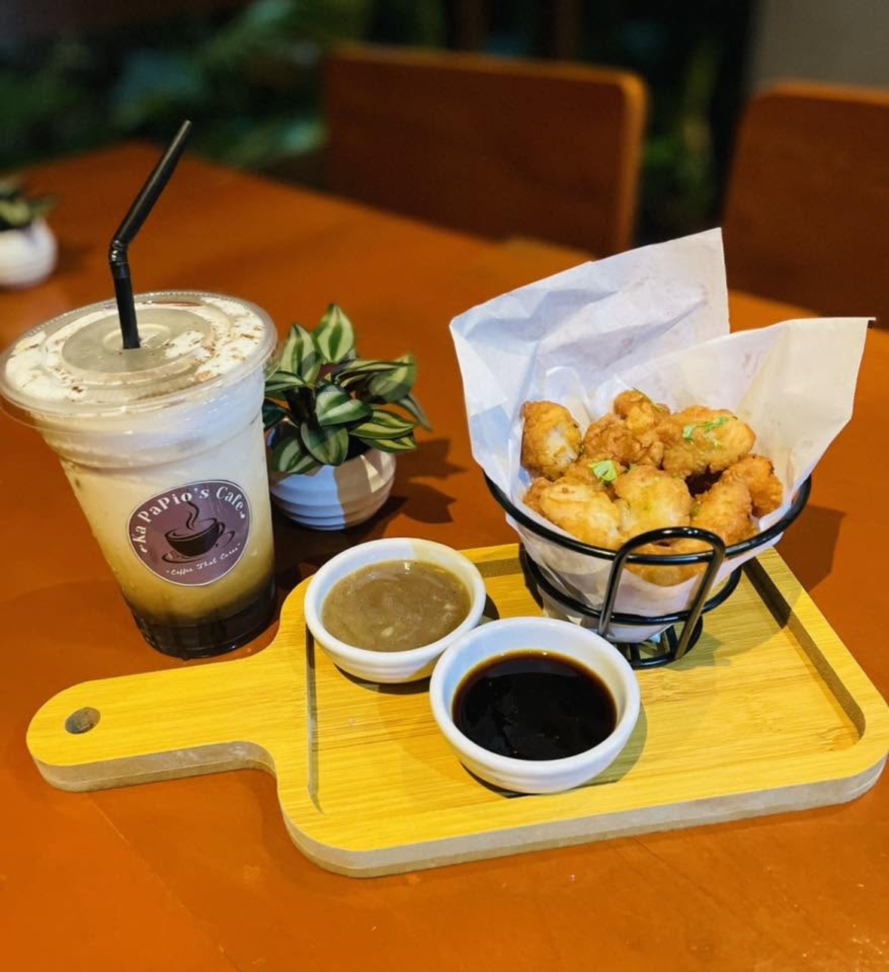 Basket of fried bites with two dipping sauces and a cold drink
