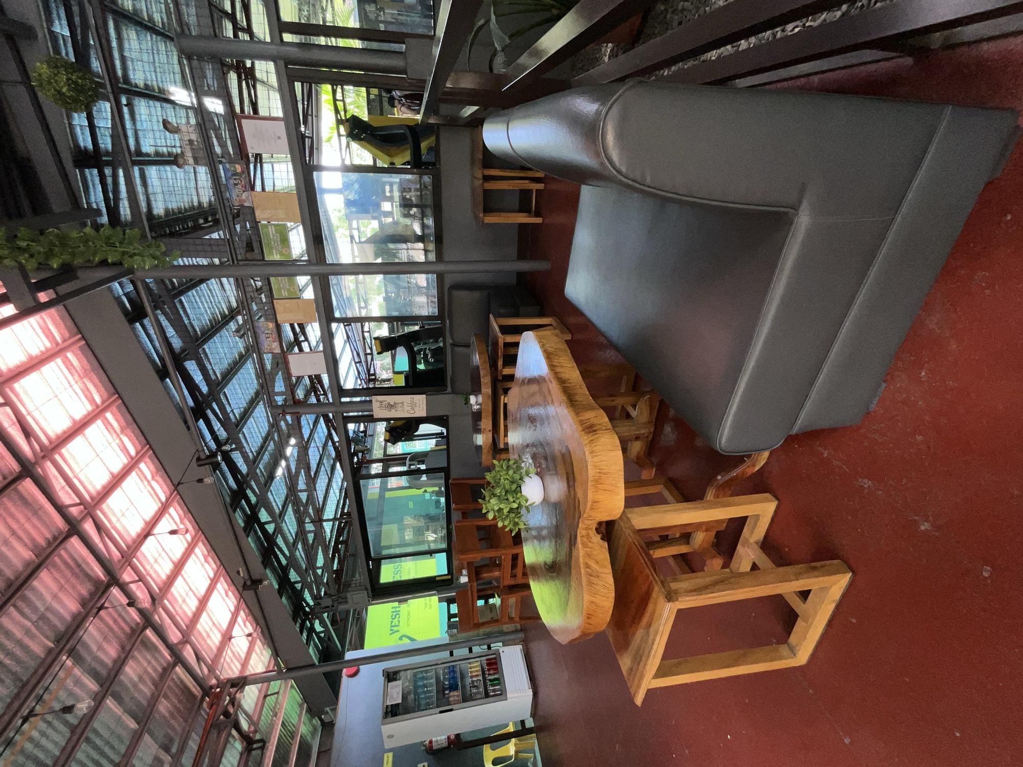Long live-edge wooden table and a leather bench inside Ka PaPio's Cafe