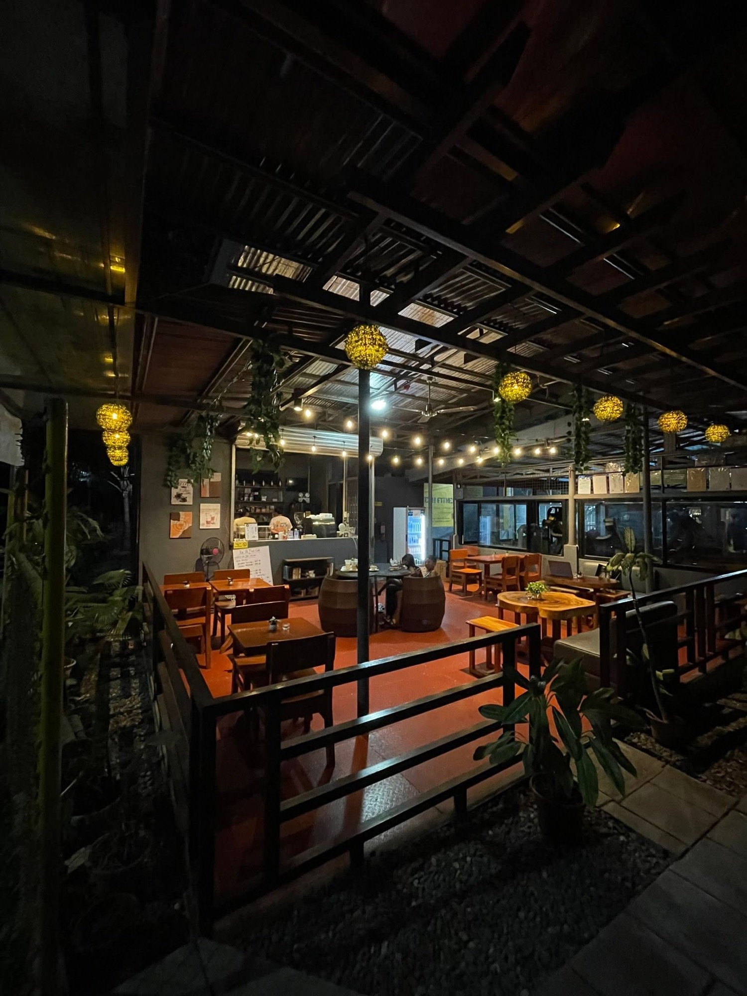 Ka PaPio's Cafe after dark with pendant lights over the wooden tables