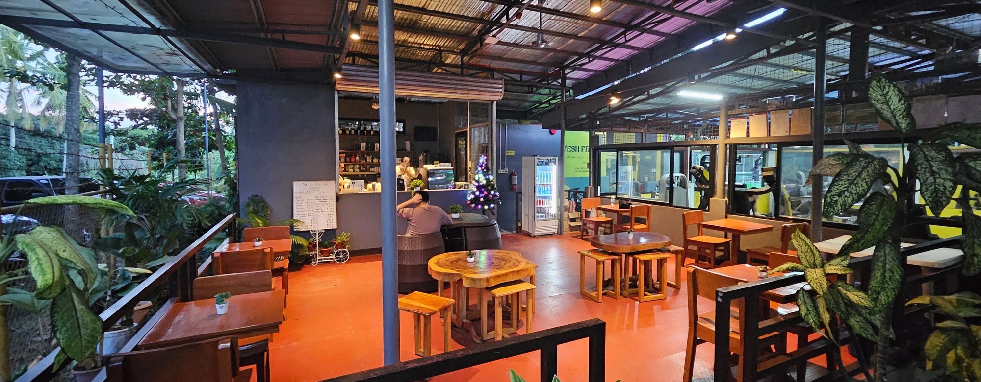 Open-air cafe seating with wooden tables and orange chairs