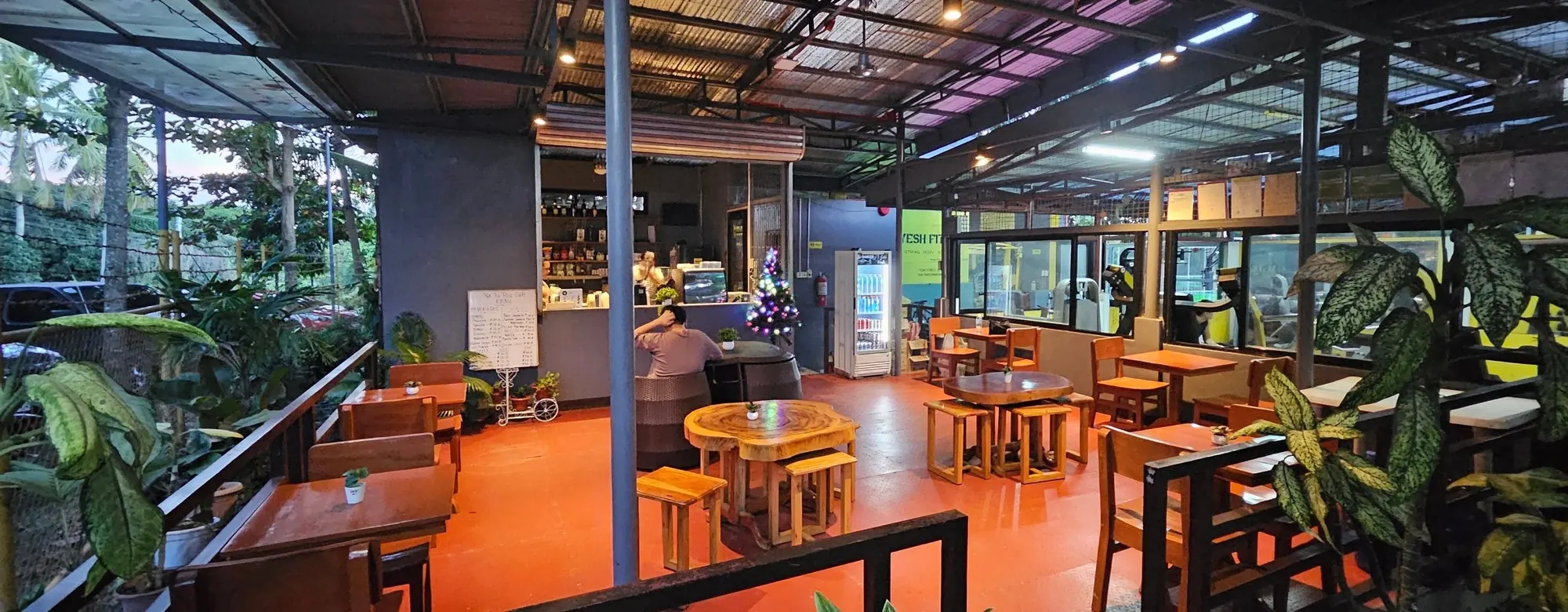 Open-air cafe seating with wooden tables and orange chairs