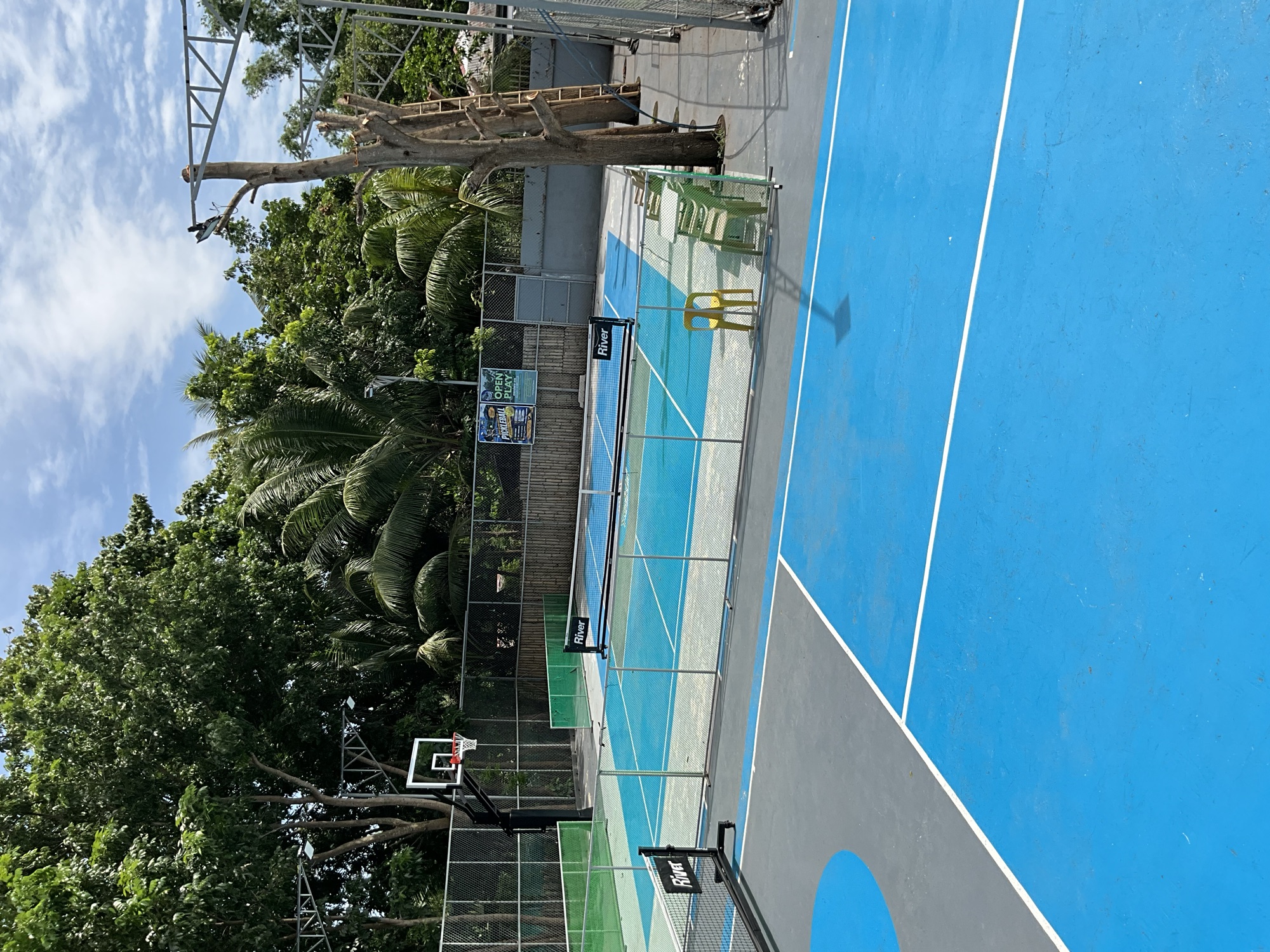 Two outdoor courts painted blue and green, seen from the side