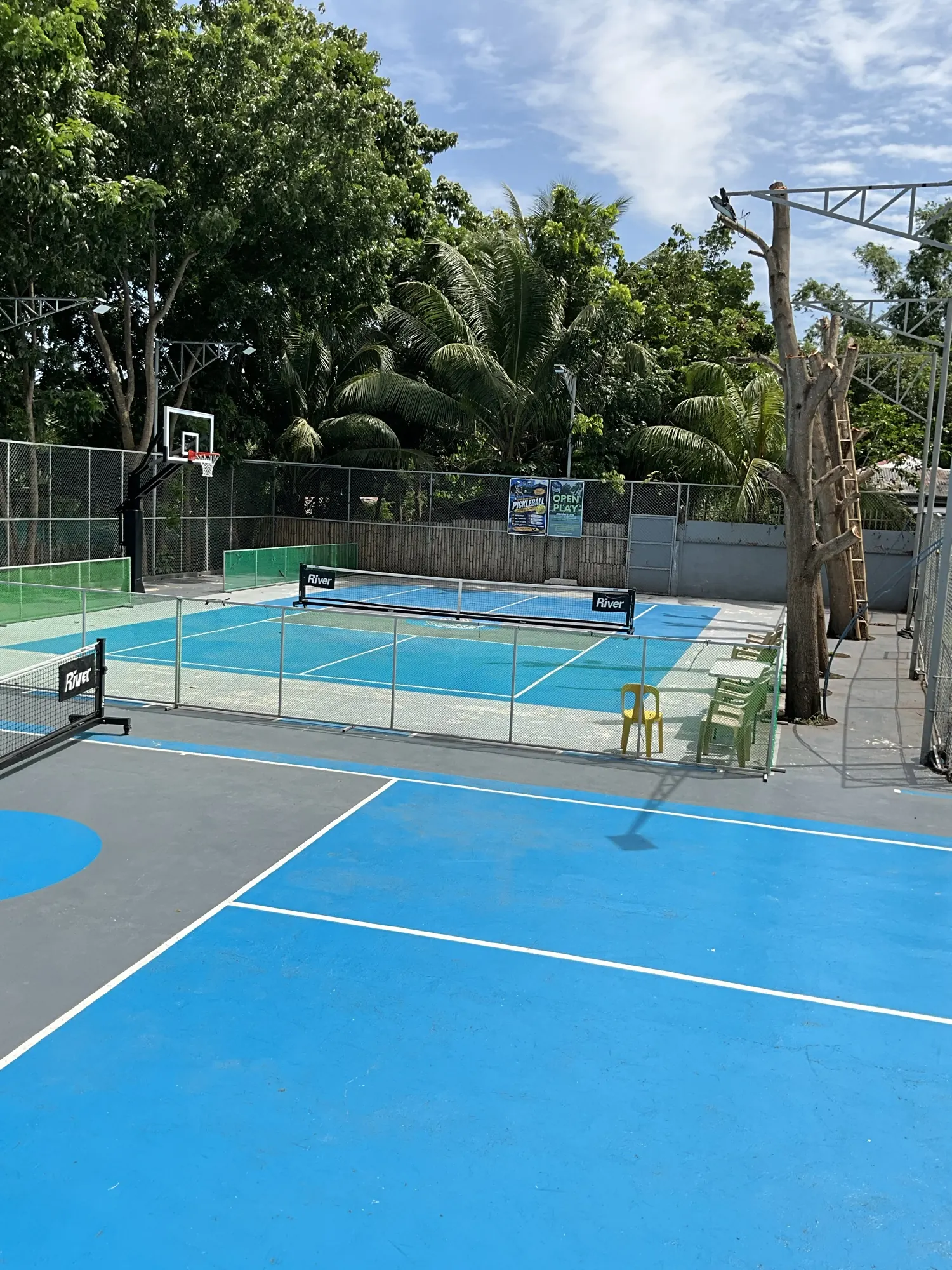 Two outdoor courts painted blue and green, seen from the side