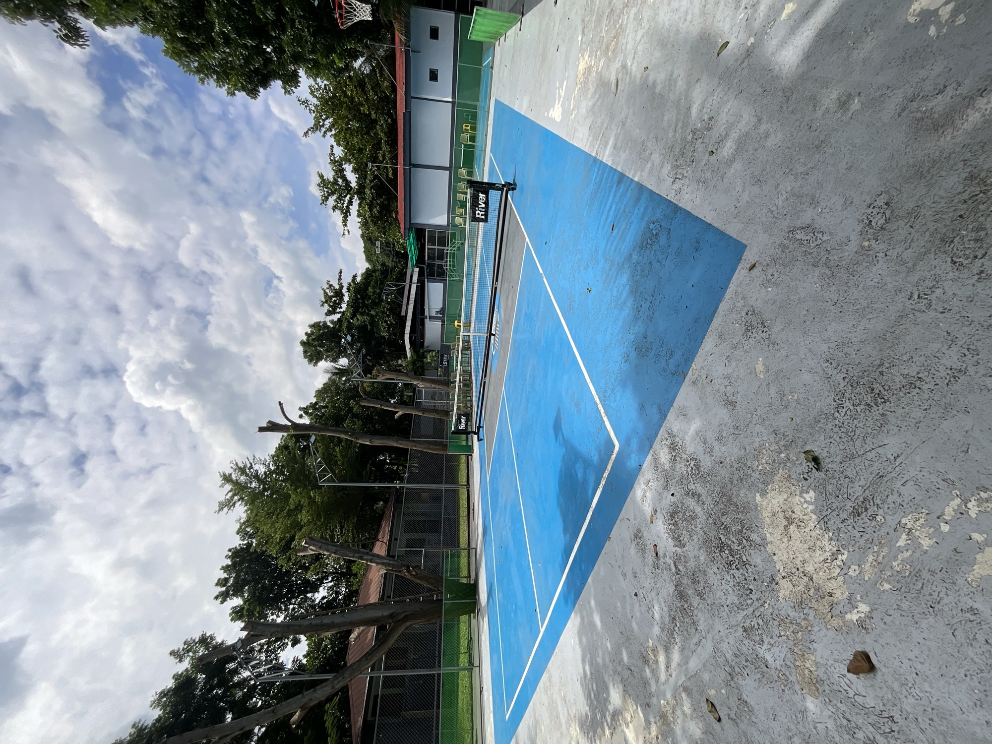 Court and net with the clubhouse roof behind the fence
