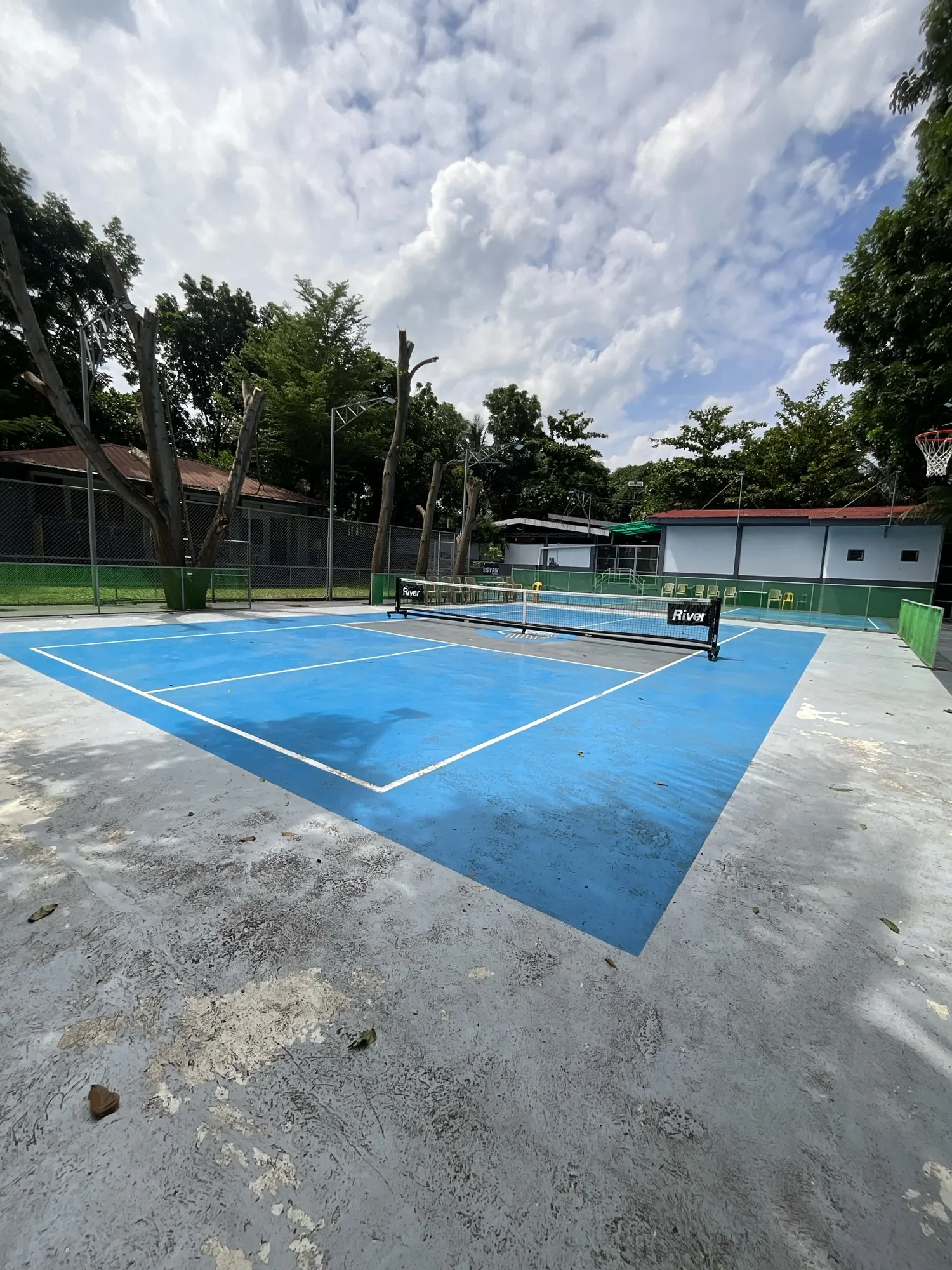 Court and net with the clubhouse roof behind the fence