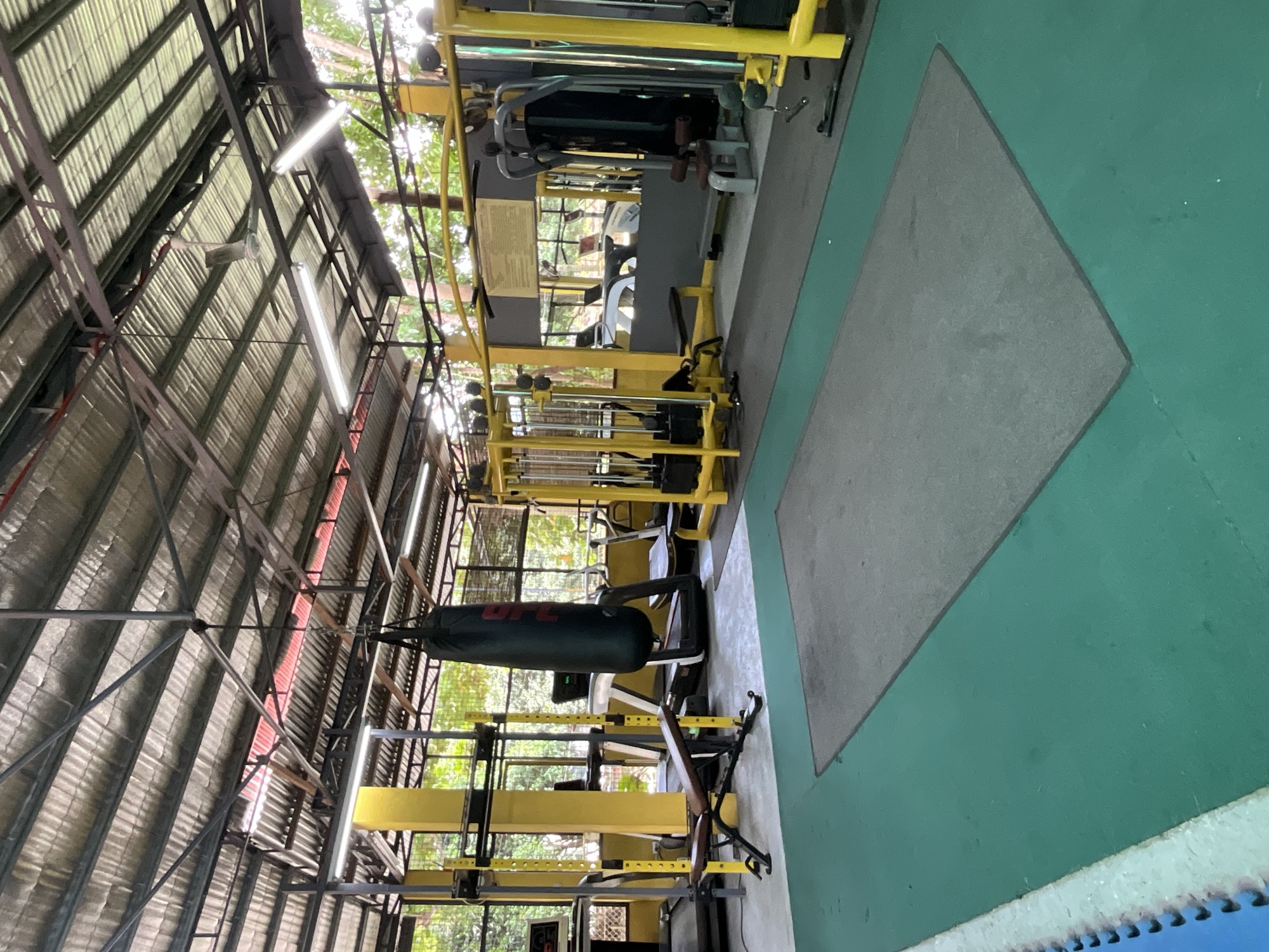 The matted functional zone at Yesh Fitness with a rig and heavy bag under the open roof