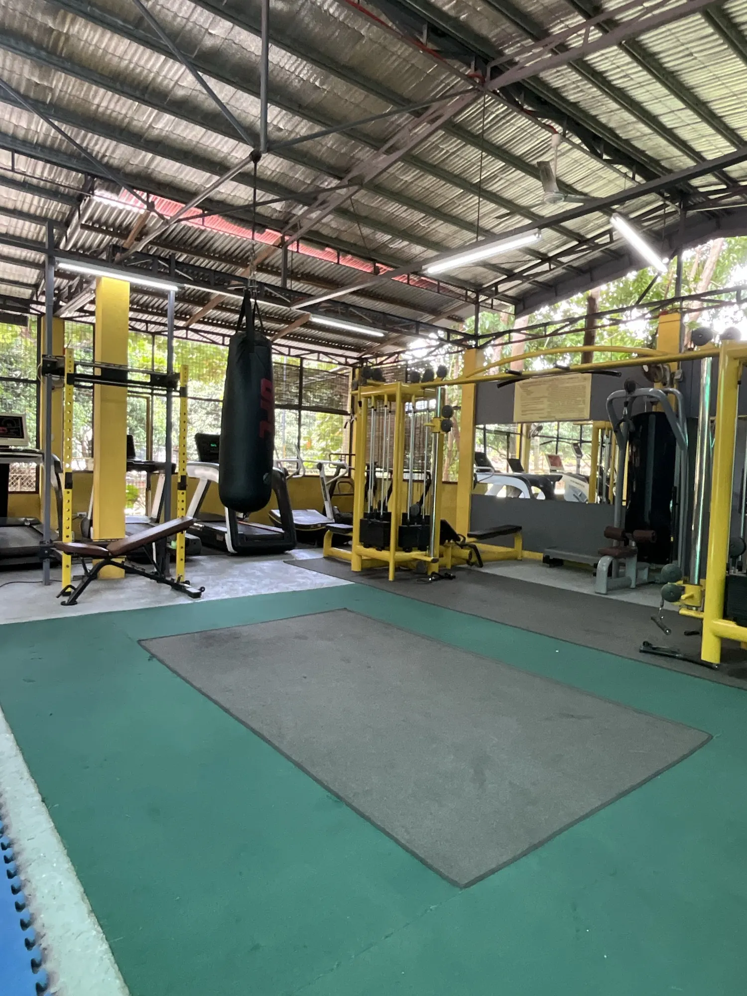 The matted functional zone at Yesh Fitness with a rig and heavy bag under the open roof