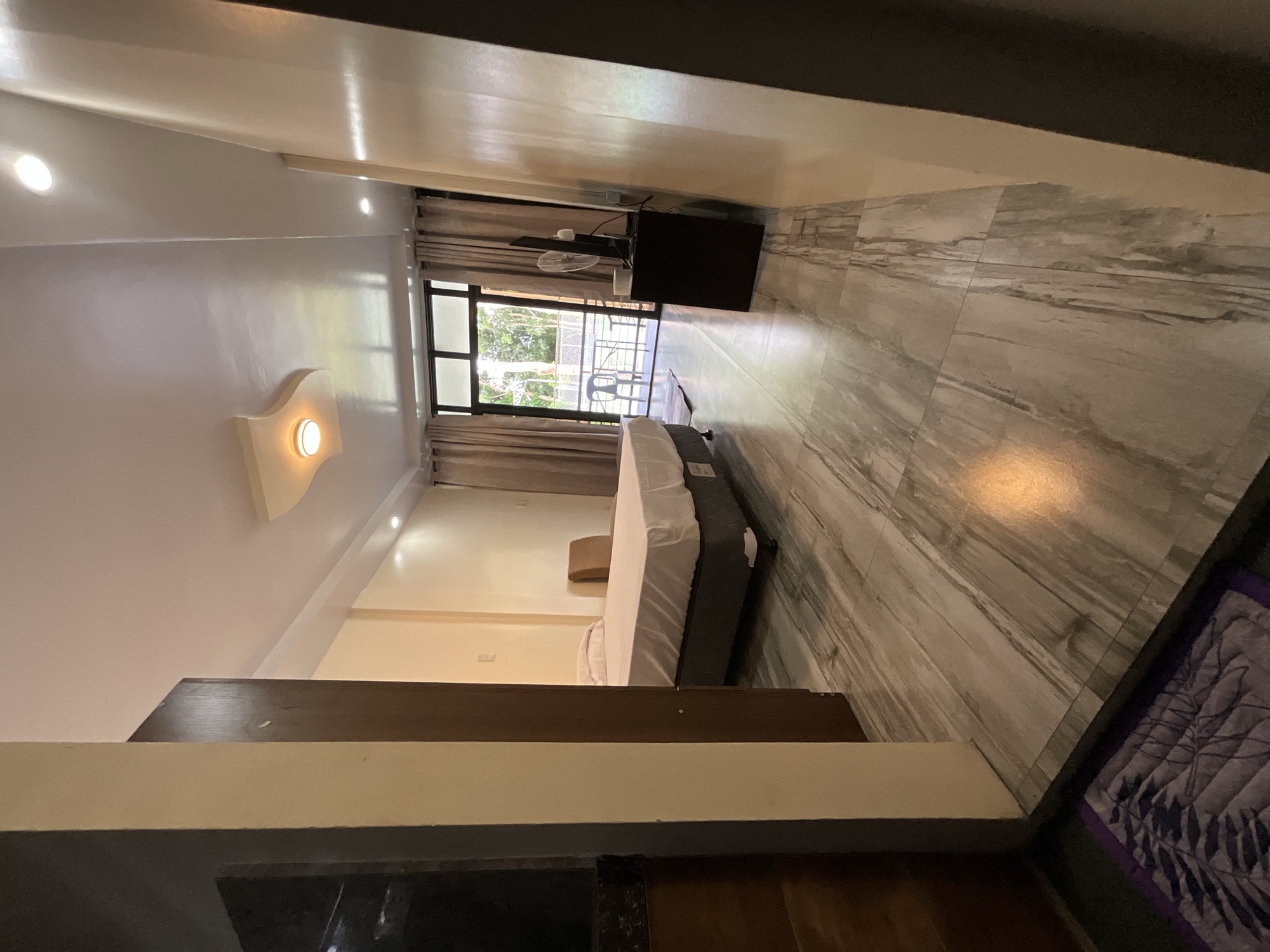 Room with a bed and a sliding door onto the balcony