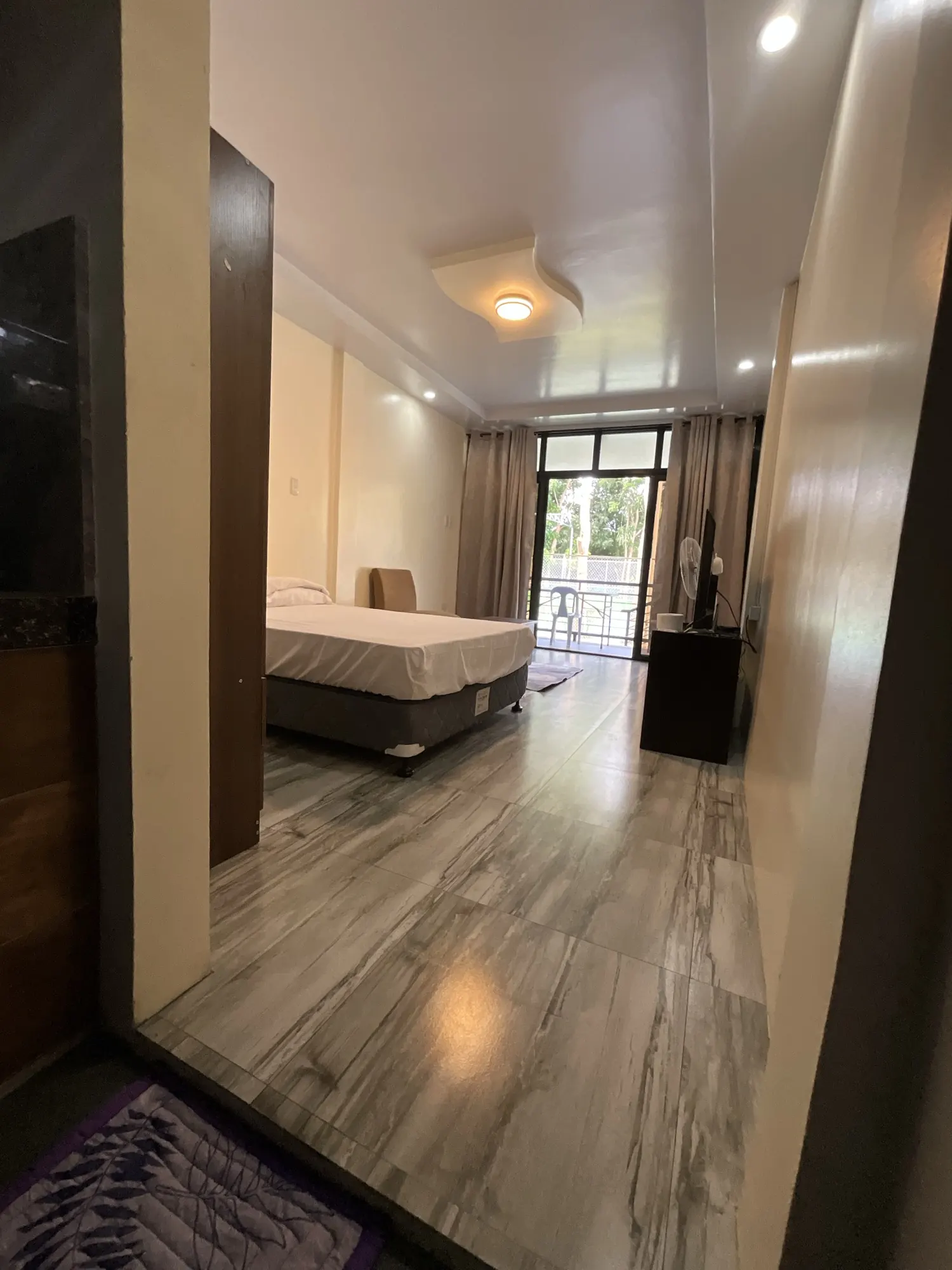 Room with a bed and a sliding door onto the balcony