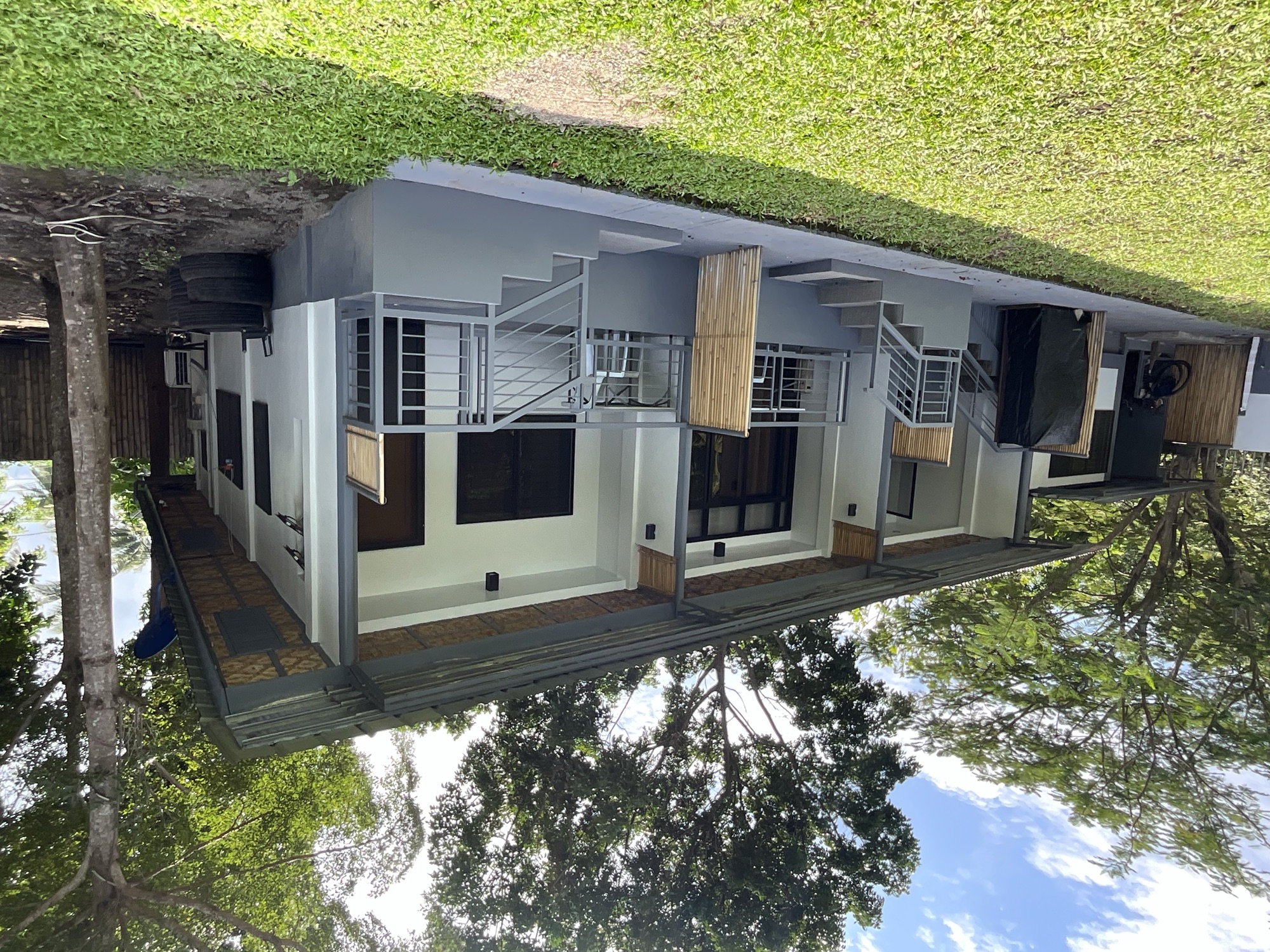 The row of rooms at PaPio's Nest seen across the lawn under tall trees