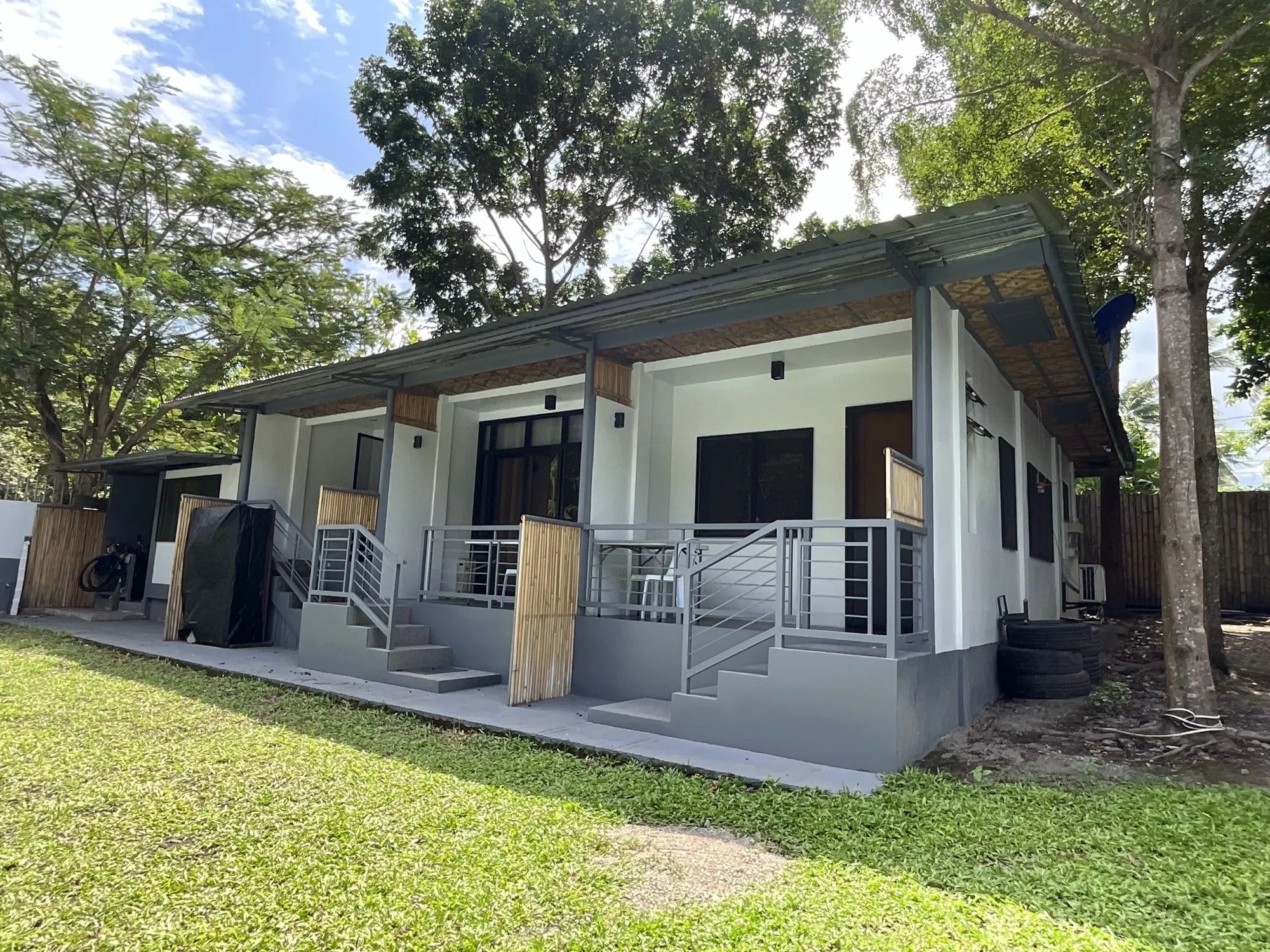 The row of rooms at PaPio's Nest seen across the lawn under tall trees