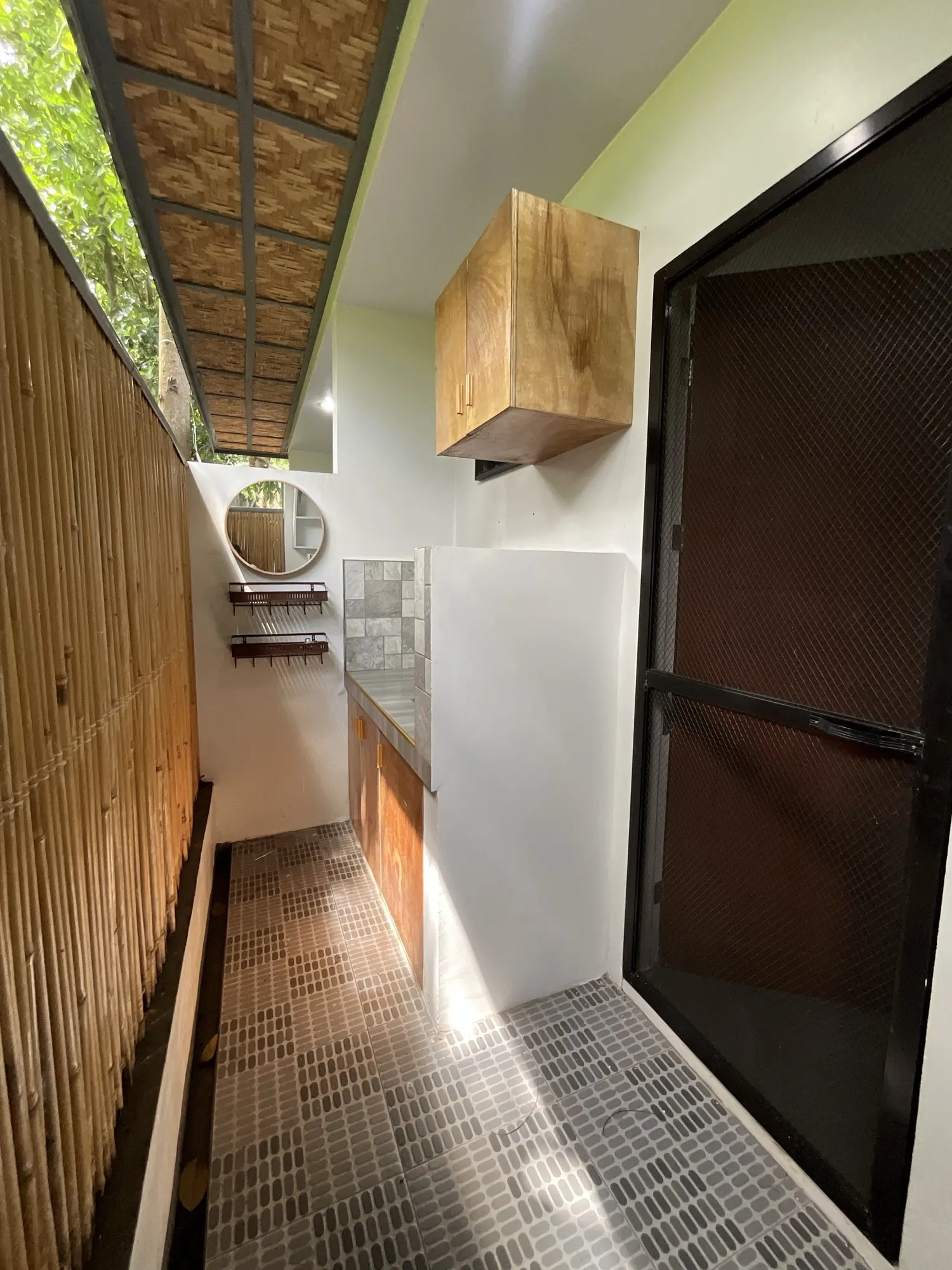 Outdoor wash area finished in bamboo with a round mirror