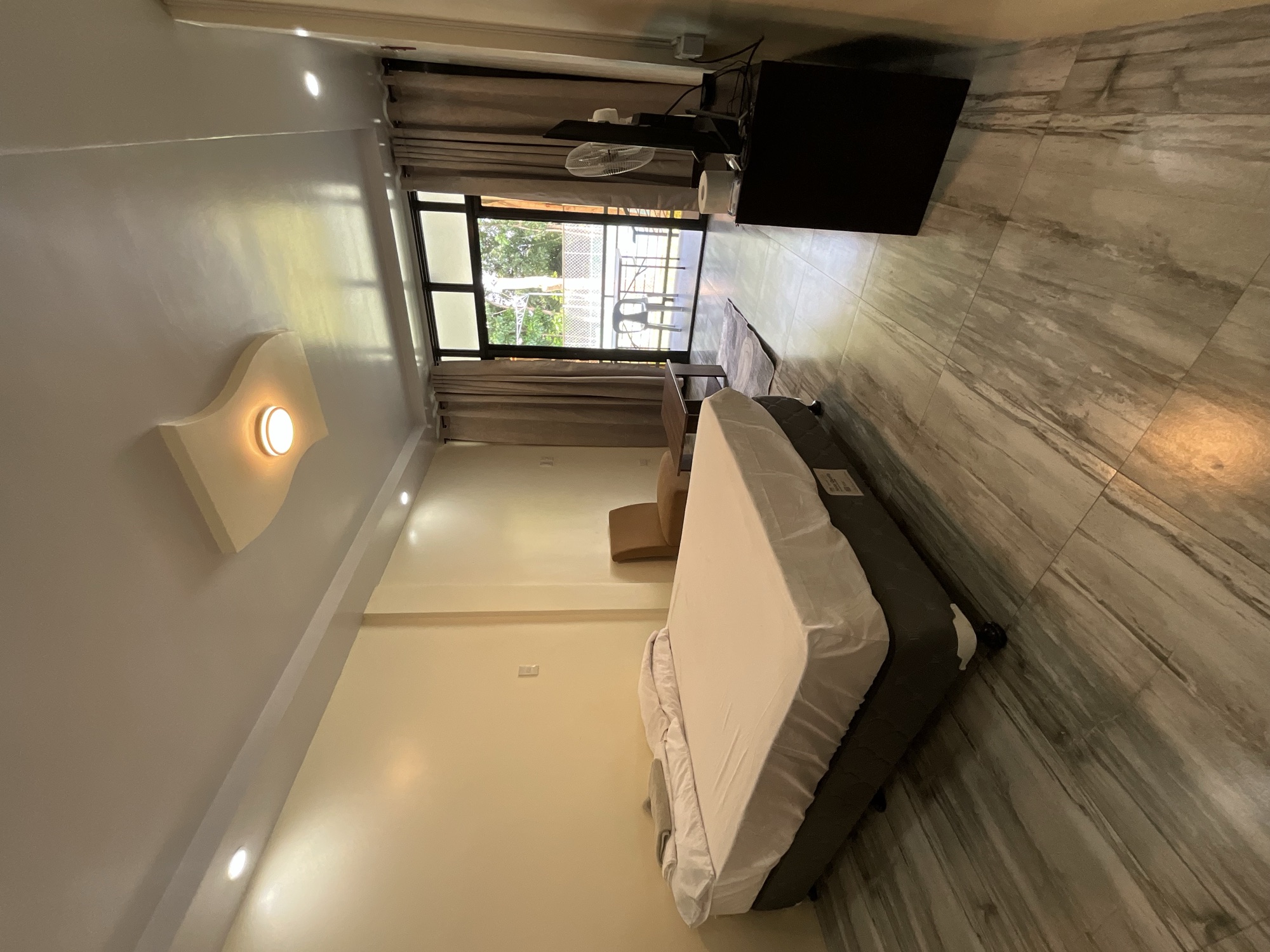 Bright room with a bed and a glass door opening to a balcony