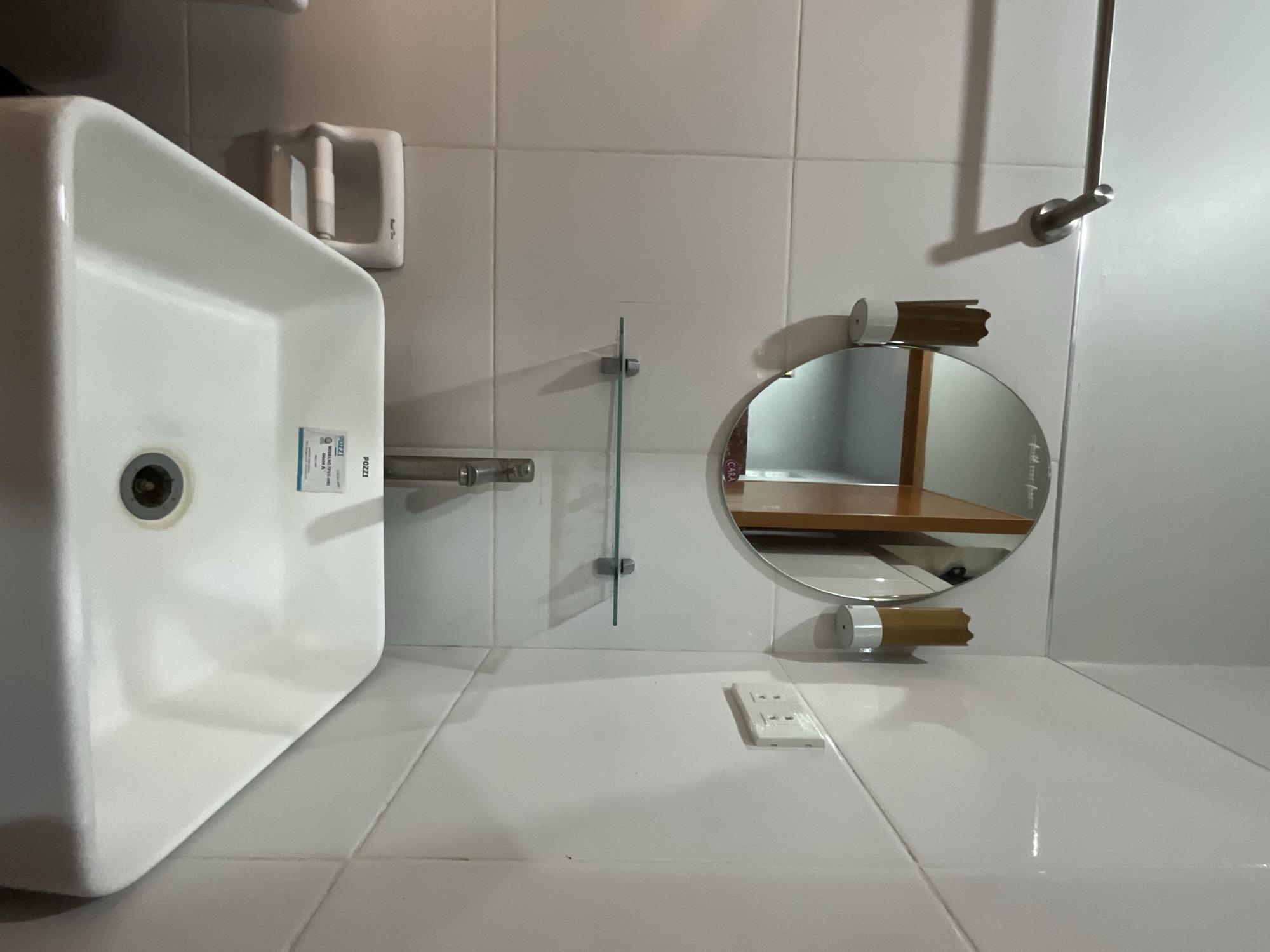 Basin, round mirror and wall lights in the bathroom