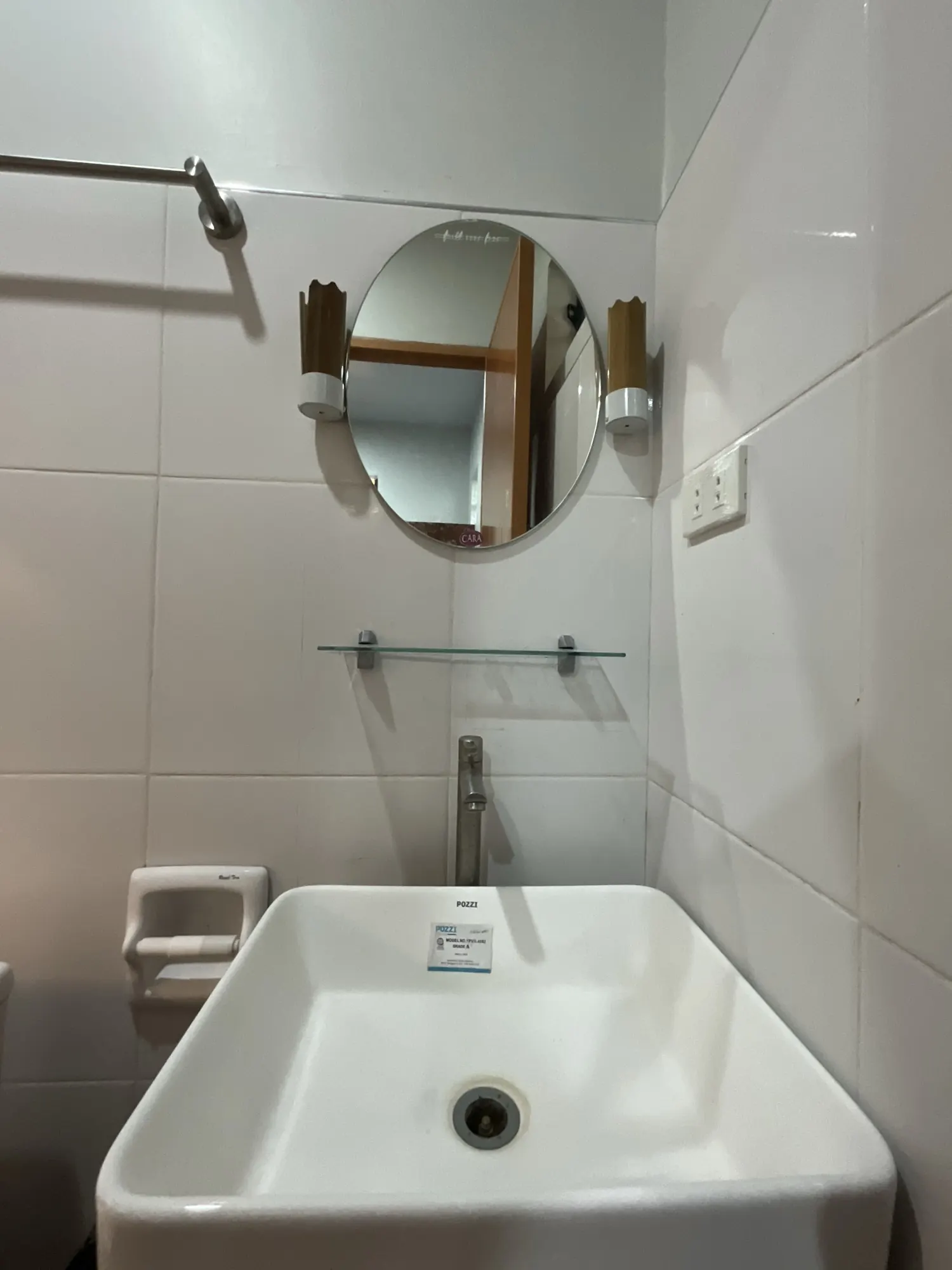 Basin, round mirror and wall lights in the bathroom